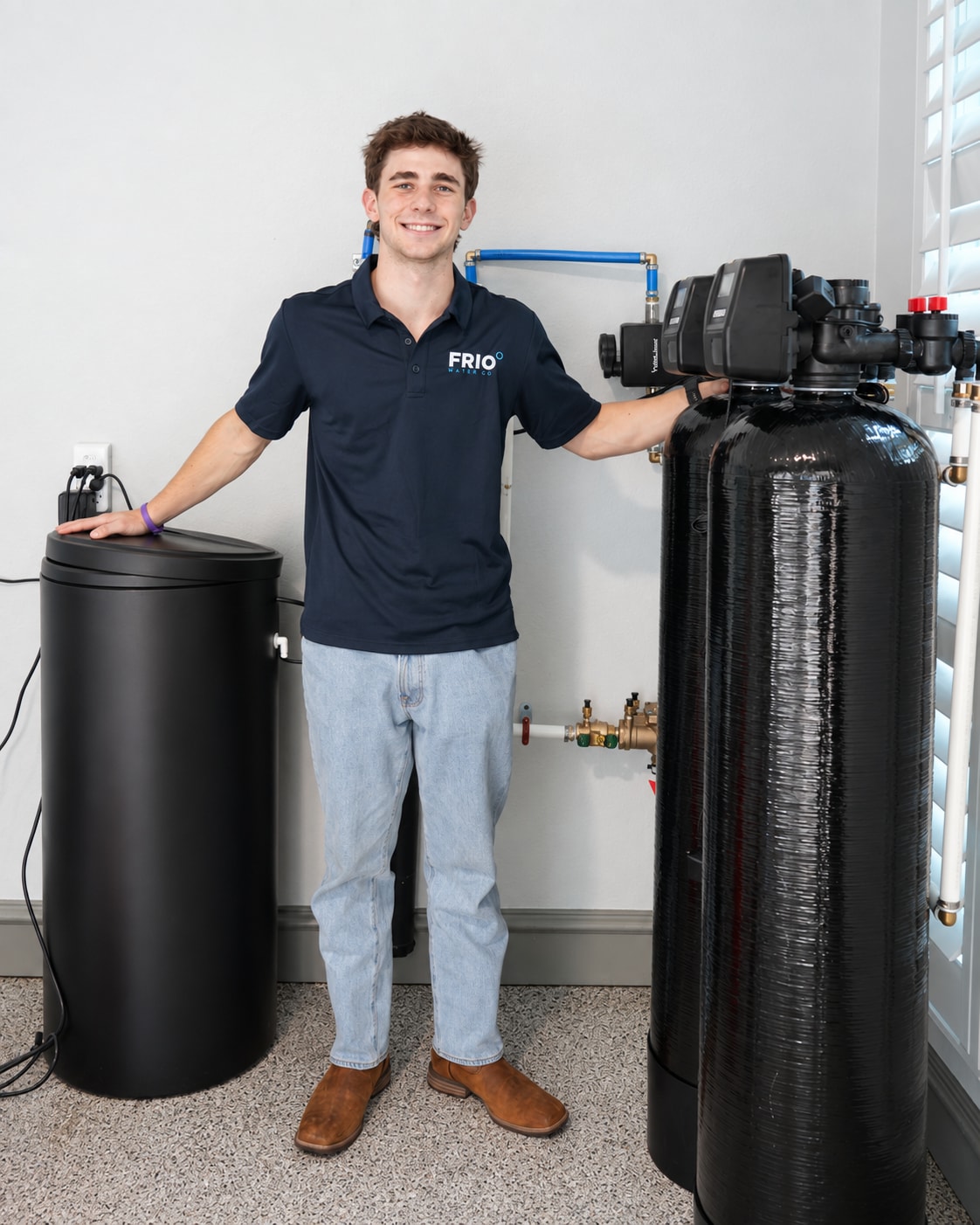 Brooks Mackintosh, founder of Frio Water Co, beside a home water treatment system
